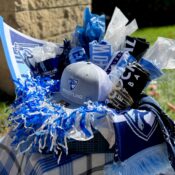 A gift backet with a UIU Athletics hat, pom poms, drink containers and more