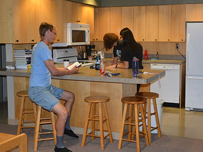 A group of students gather aroud a high table
