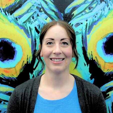 Scotti Hagensick is an intern-counselor for Upper Iowa University. She is wearing a black cardigan overtop of a sky blue shirt. She has dark brown hair pulled back.