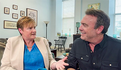 UIU President Kathy Franken and The College Tour Host Alex Boylan sit down for a coffee and conversation in an office setting