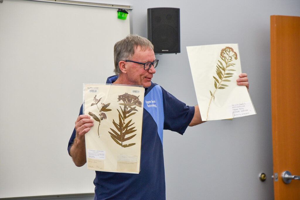 Dr. Figdore showing preserved herbs during a presenation