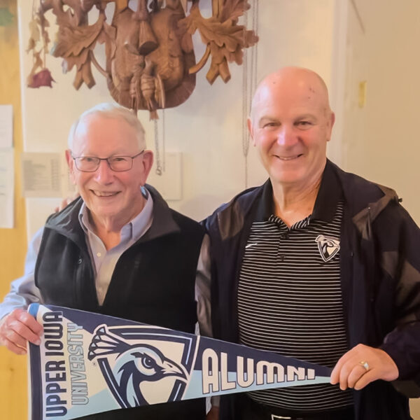 Jim Odle and Dr. Duffy hold a UIU Alumni pennant.