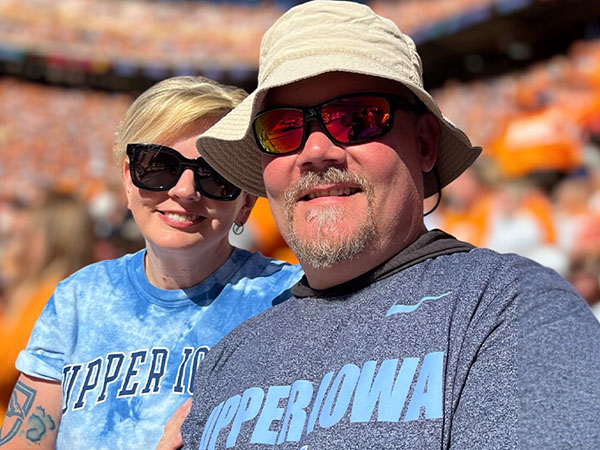 Photo of Josie & Jim Baun wearing sunglassess at a sporting event