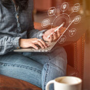Person using a laptop with digital communication icons overlayed