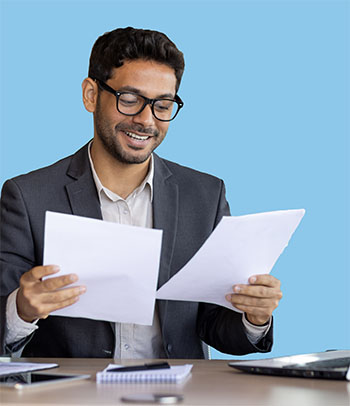 A man inspect some reports while sitting at a desk