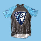 A grey and blue cycling jersey with a large UIU Peacock Athletics Logo
