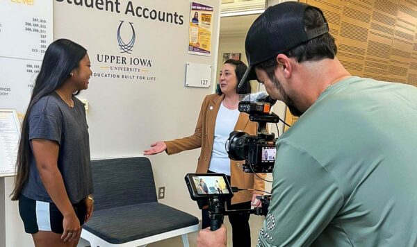 Two students converse with each other while getting filmed with a video rig