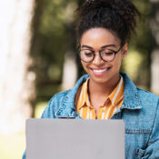 Young woman with glasses using a laptop outdoors