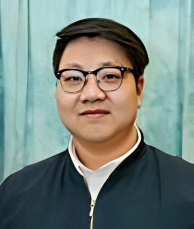 Ziyuan Li pictured in fron tof a light blue background